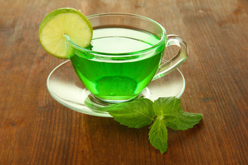 Transparent cup of green tea with lime and mint