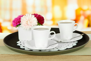 Cups of coffee on tray on table in cafe