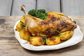 Roasted chicken with vegetables on wooden table