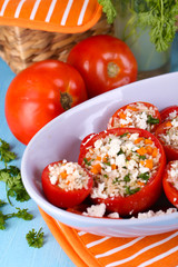 Stuffed tomatoes in bowl on wooden table close-up