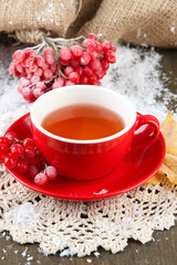 Still life with viburnum  tea in cup, berries and snow,