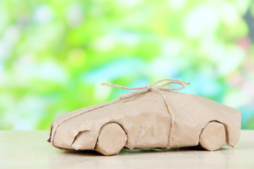 Car wrapped in brown kraft paper, on nature background