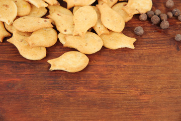 Delicious crackers with spices on wooden background