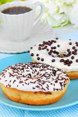 Sweet donuts with cup of tea on table close-up