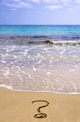 question mark sign in sand beach, sea water and clear blue sky