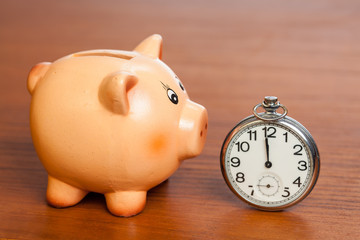 Pocket watch on a piggy bank