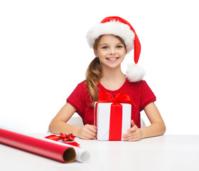 smiling girl in santa helper hat with gift box