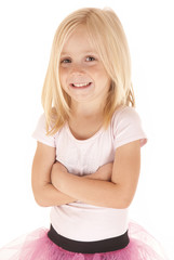 Cute young girl with arms folded smiling in pink tutu