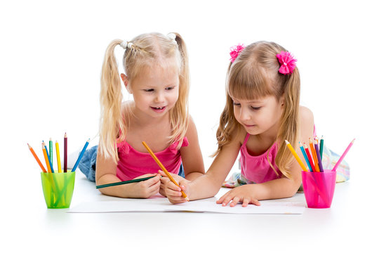 two girls drawing with color pencils together over white backgro