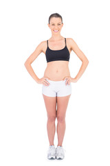 Obraz premium Smiling woman in sportswear hands on hips looking at camera