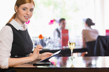 Businesswoman using tablet and looking at camera