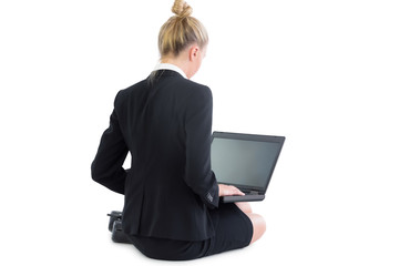 Calm pretty businesswoman sitting on floor using her laptop
