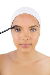 Sensual woman wearing headband using eyebrow brush