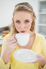 Content cute blonde holding a cup