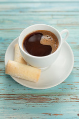 Cup of coffee and biscuits on old wooden table