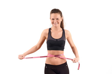 Fit girl measuring her waist with a measuring tape in inch
