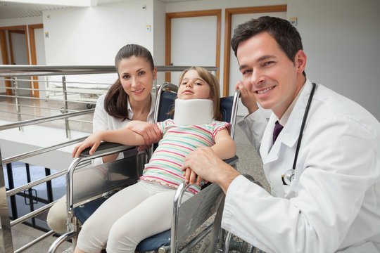 Smiling doctor, mother and her child in wheelchair