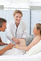 Obraz premium Pregnant woman with her husband listening to the nurse