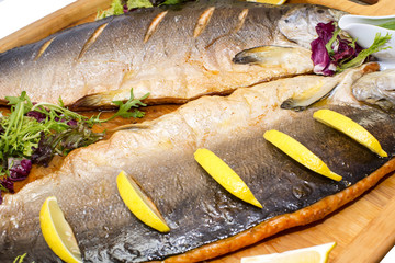 Baked salmon with vegetables on a wooden platter
