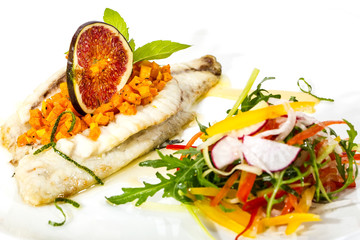 Baked fish with salad on a white background in restaurant