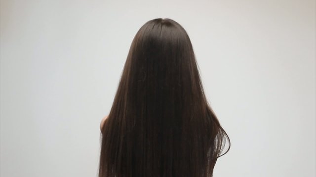 Young woman gently touching her long hair
