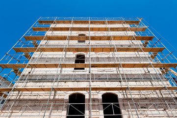 old building during reconstruction with wooden scaffolding