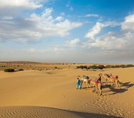 Two cameleers (camel drivers) with camels in dunes of Thar deser