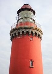 Old red lighthouse at the coast of the Northern Sea