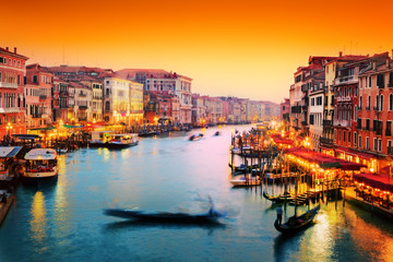 Fototapeta na wymiar Wenecja, Włochy. Gondola pływa na Canal Grande na zachodzie słońca