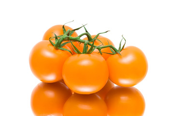 bunch of ripe tomatoes on a white background with reflection
