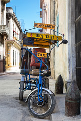 Street in Havana with an  old bicycle and shabby buildings