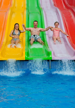 Father with daughters on tropical slide