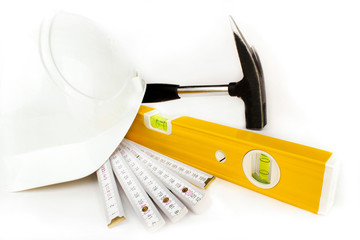 Wasserwaage, Zollstock, Hammer und Bauhelm