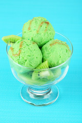 Delicious ice cream on glass vase on blue tablecloth