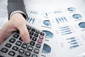Man hand with pen and business report on table