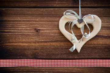 clipped wooden heart hanging on sun burned wood planks