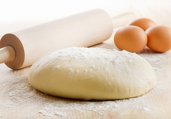 Dough with eggs on wooden table. Selective focus