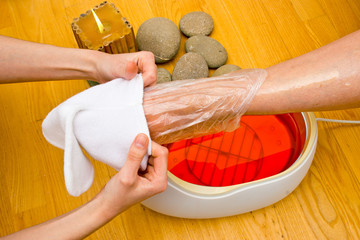 woman foot in paraffin bath at the spa
