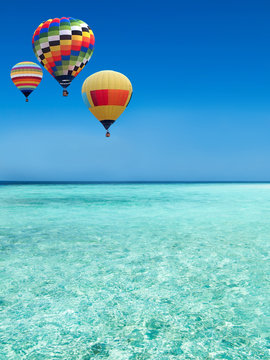 Hot air balloons travel over the sea