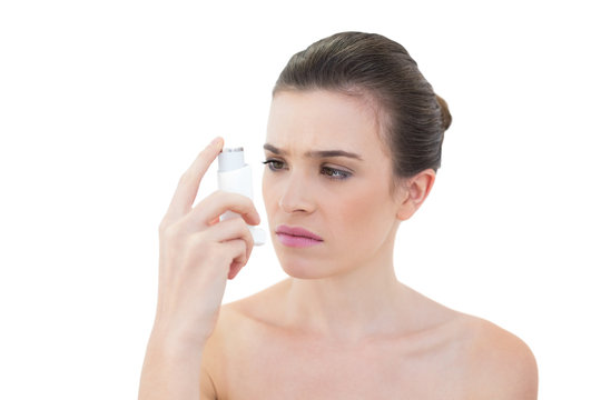 Puzzled Natural Brown Haired Model Looking At An Asthma Inhaler