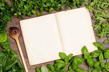 Buch für Rezept mit Kochlöffel und Kräuter