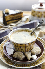 Coffee, brown sugar and piece of chocolate caramel cake