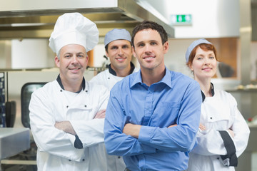 Young manager posing with some chefs