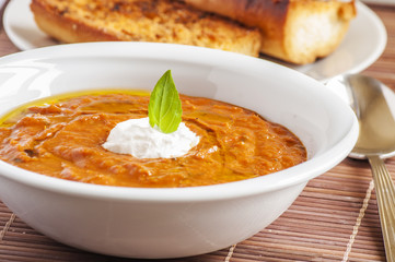 A picture of a white bowl full of fresh tomatoes soup