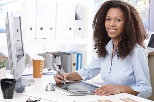 Smiling office worker with drawing table
