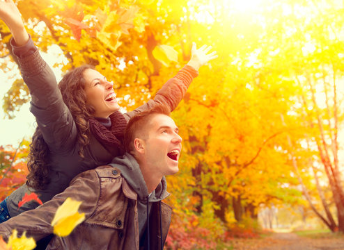 Happy Couple In Autumn Park. Fall. Family Having Fun Outdoors