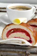 Coffee and croissant with butter and jam served on a tray