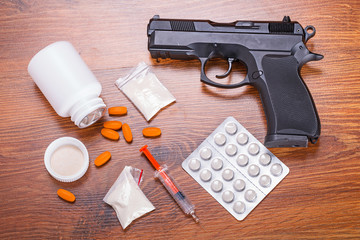 Obraz premium Set of narcotics and handgun on wooden table