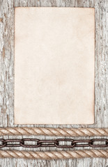 Metal chain, rope and sheet of paper on the old wood