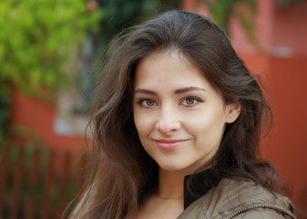 Obraz premium Cute woman with green eyes looking happy outdoors background